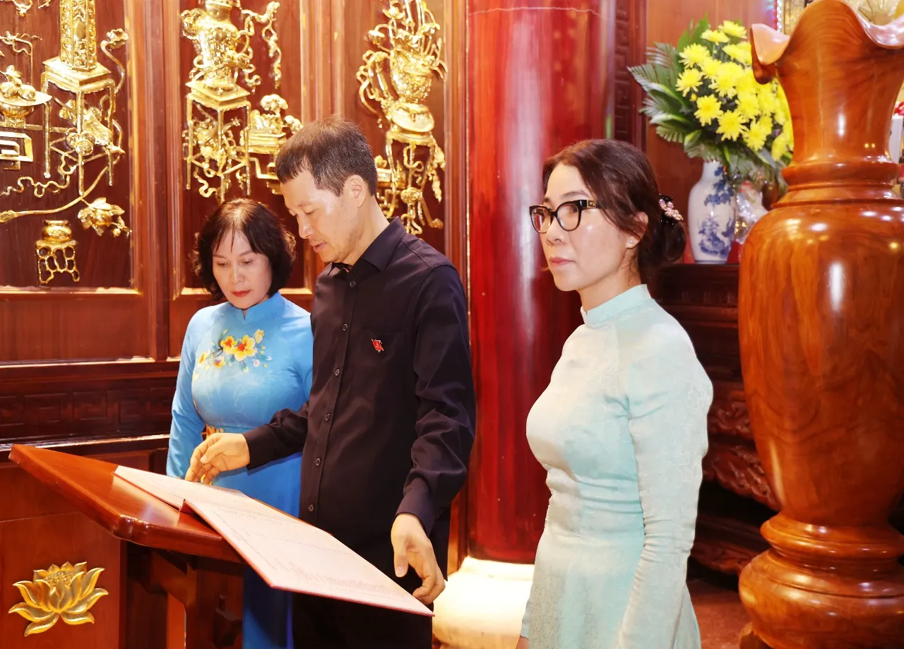 Các đồng chí lãnh đạo thành phố và phường Xuân Lộc xem sổ ghi danh các anh hùng liệt sĩ