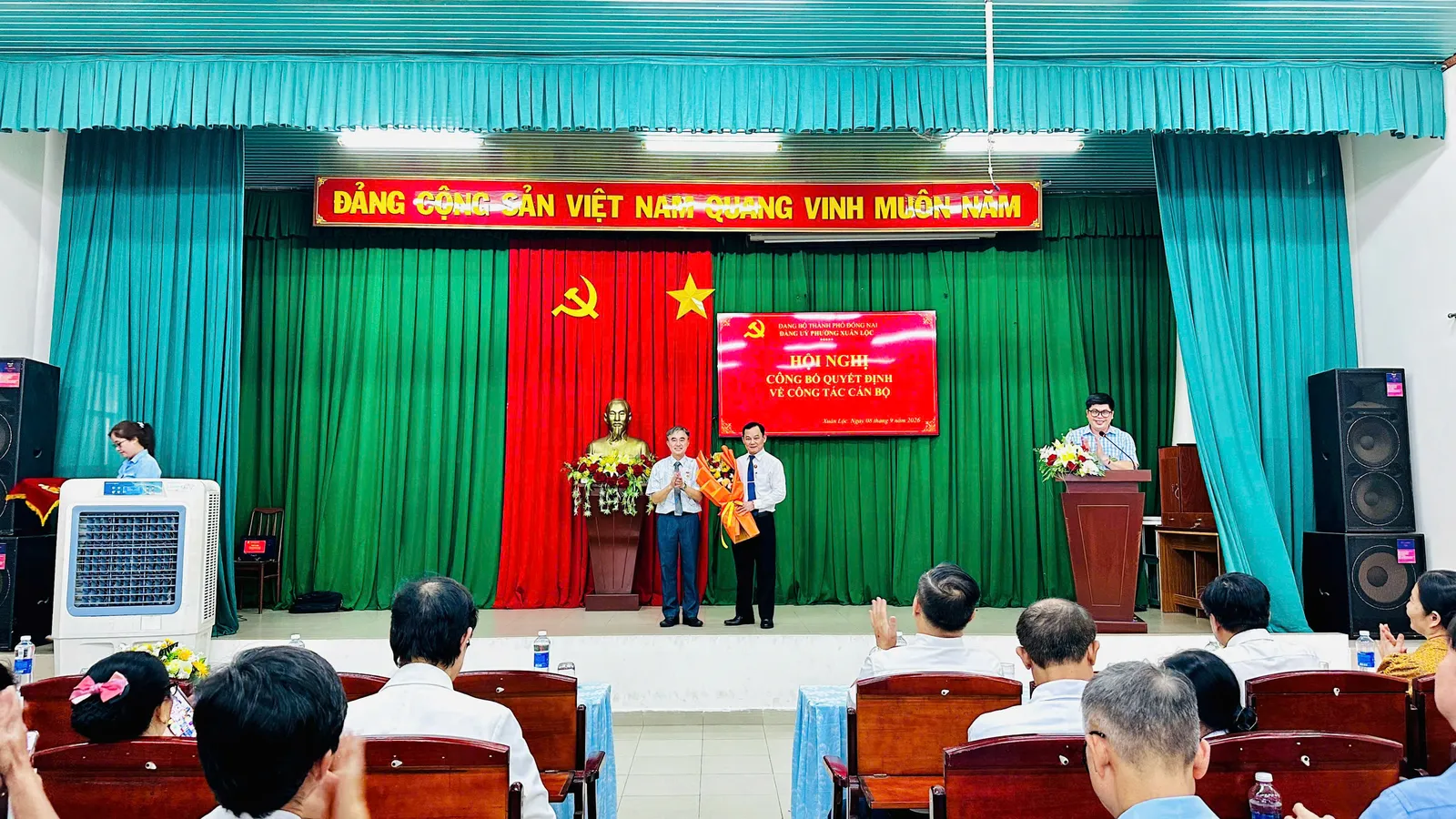 Ông Bùi Thái Chiến nhận hoa chúc mừng của Ban giám đốc trung tâm y tế khu vực Xuân Lộc